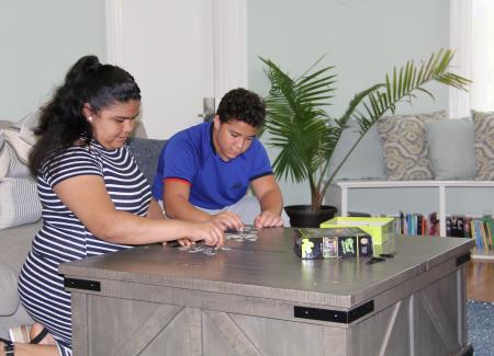 Two students playing a board game at a table